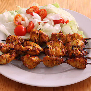Chicken tikka with lettuce and tomato salad.