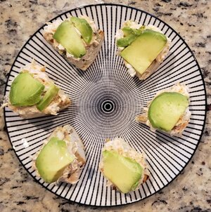 Smoked salmon and cream cheese spread on bagels topped with avocado.jpg