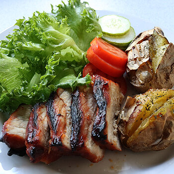 Char sui with grass and tomatoes and jacket potatoes.
