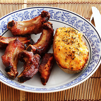 Pork ribs with honey and stuffed jacket potato.