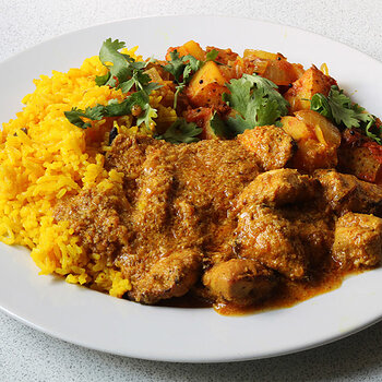 Chicken tikka masala with potato and onion bhaji and yellow aromatic rice.