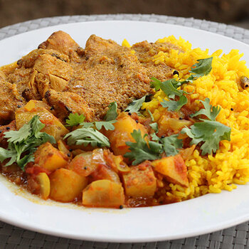 Chicken tikka masala with potato and onion bhaji and yellow aromatic rice.