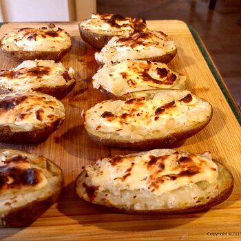 Twice baked potatoes with melted white cheddar cheese