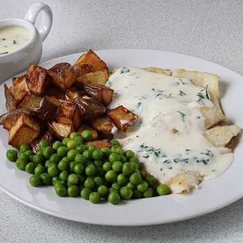 Halibut with roast potatoes and peas and parsley sauce.