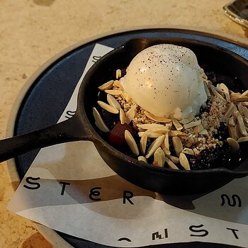 Plum crumble with almond flakes and vanilla soy ice cream