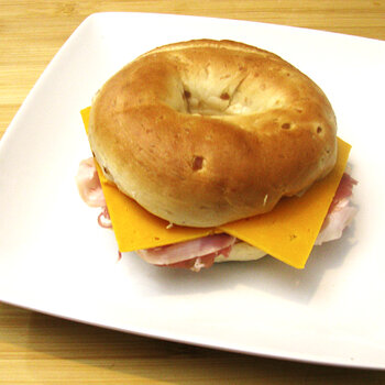 Onion Bagel with Prosciutto and Sliced Cheddar