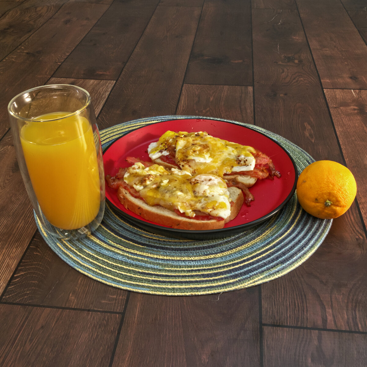 Bacon and Eggs on Rye Bread with Orange Juice and an Orange