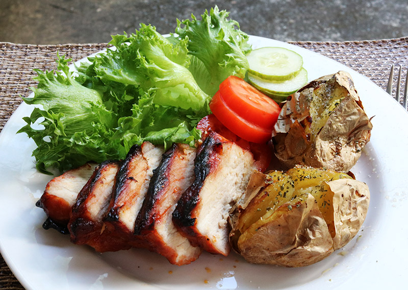 Char sui with grass and tomatoes and jacket potatoes.