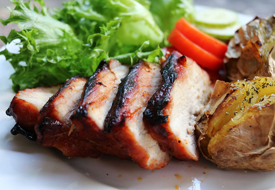 Char sui with grass and tomatoes and jacket potatoes.