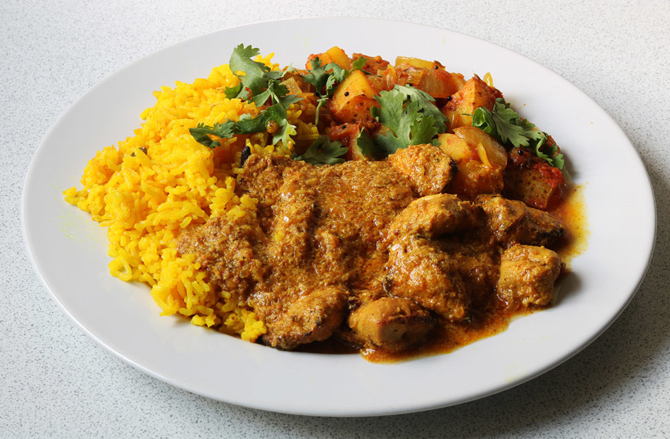 Chicken tikka masala with potato and onion bhaji and yellow aromatic rice.