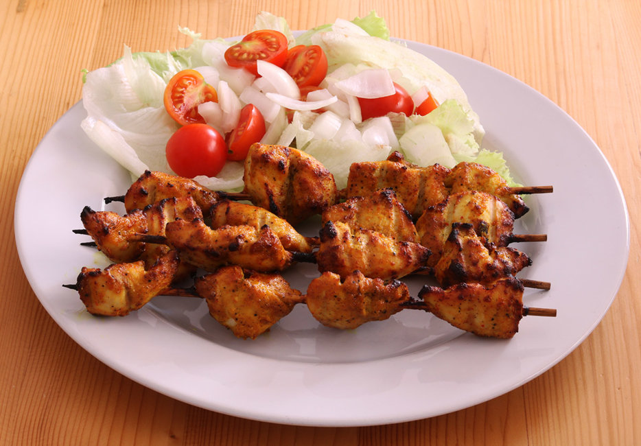 Chicken tikka with lettuce and tomato salad.