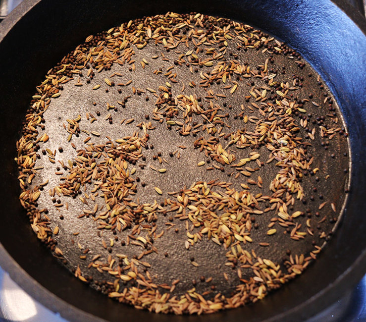 Dry frying cumin, fennugreek and black onion seeds.