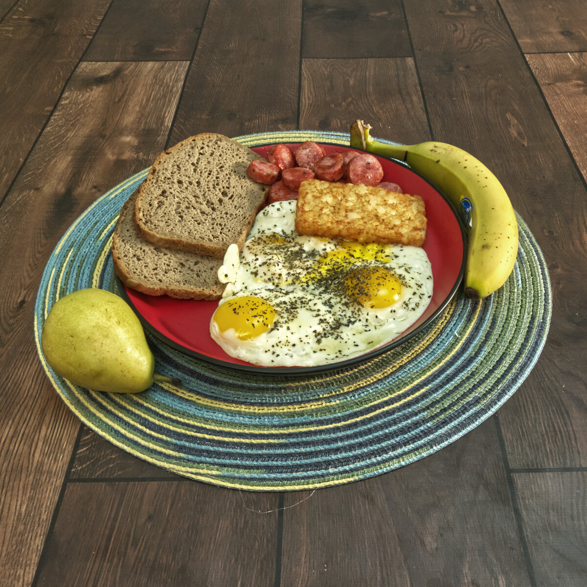 Eggs, Bratwurst, Pumpernickel Bread, a Banana and a Pear