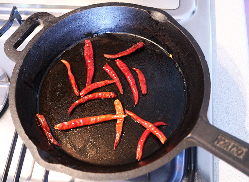 Frying dried chiles.