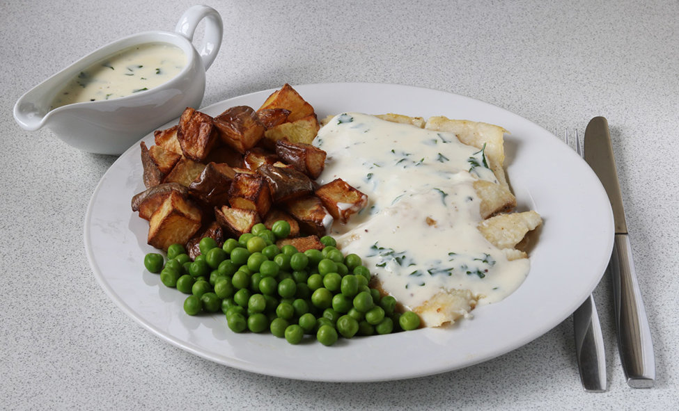 Halibut with roast potatoes and peas and parsley sauce.
