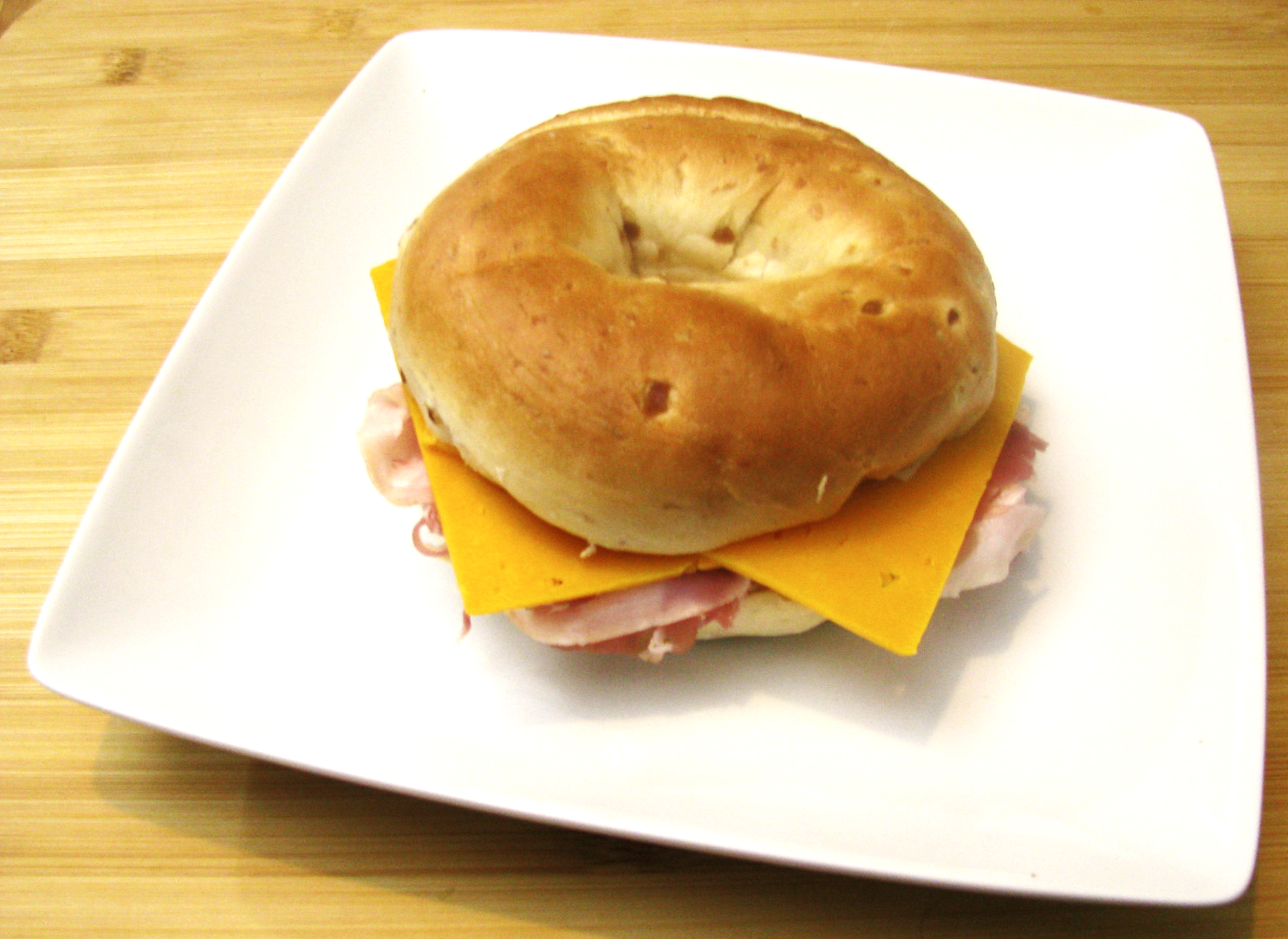 Onion Bagel with Prosciutto and Sliced Cheddar