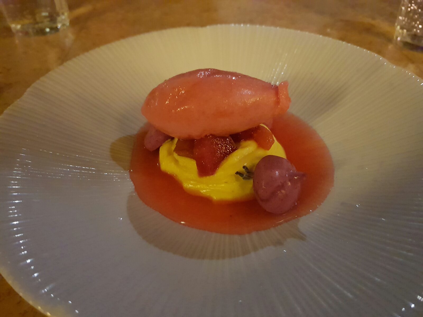 Raspberry sorbet on a vanilla custard with a berry coullie